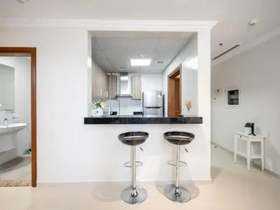 a kitchen with two bar stools and a counter at Elegant 1BR near from Dubai Mall & Burj Khalifa in Dubai