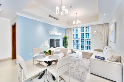 a living room with a table and chairs and a tv at Elegant 1BR near from Dubai Mall & Burj Khalifa in Dubai