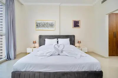 a bedroom with a white bed with a bow on it at Elegant 1BR near from Dubai Mall & Burj Khalifa in Dubai