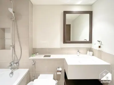 a white bathroom with a sink and a mirror at Seaside 1BR Retreat , Beach & Atlantis Views in Dubai