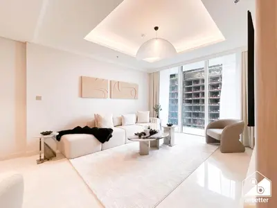 a white living room with a couch and a table at Seaside 1BR Retreat , Beach & Atlantis Views in Dubai