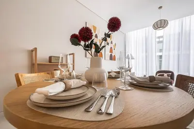 a wooden table with plates and silverware on it at District One Dubai Lagoon View Near Downtown in Dubai