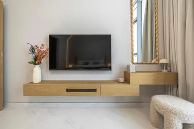 a living room with a tv sitting on a wooden entertainment center at District One Dubai Lagoon View Near Downtown in Dubai