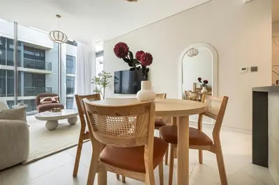 a dining room and living room with a table and chairs at District One Dubai Lagoon View Near Downtown in Dubai