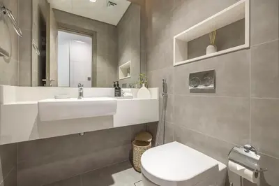 a bathroom with a sink and a toilet and a mirror at District One Dubai Lagoon View Near Downtown in Dubai