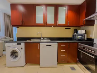 a kitchen with a washing machine and a sink at Modern 1BR in JBR, Walk to Beach & Marina in Dubai