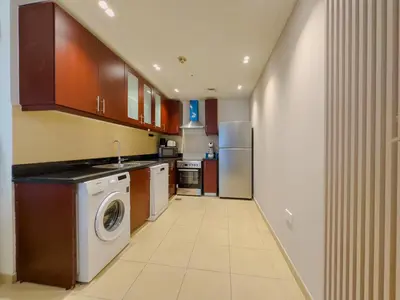 a kitchen with a washer and dryer in it at Modern 1BR in JBR, Walk to Beach & Marina in Dubai