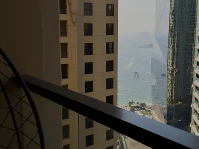 a view of the ocean from a balcony in a building at Modern 1BR in JBR, Walk to Beach & Marina in Dubai