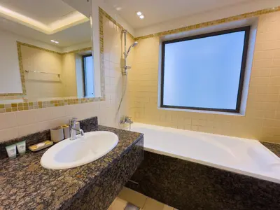 a bathroom with a sink and a tub and a window at Modern 1BR in JBR, Walk to Beach & Marina in Dubai