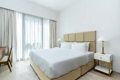 a bedroom with a large white bed and a desk at CitiHome Elegant Finishing Prime Location in Dubai