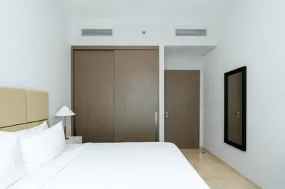 a bedroom with a large white bed and sliding doors at CitiHome Elegant Finishing Prime Location in Dubai