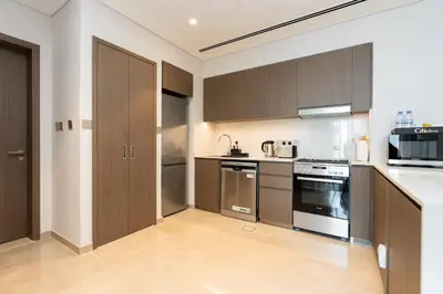 a large kitchen with brown cabinets and appliances at CitiHome Elegant Finishing Prime Location in Dubai
