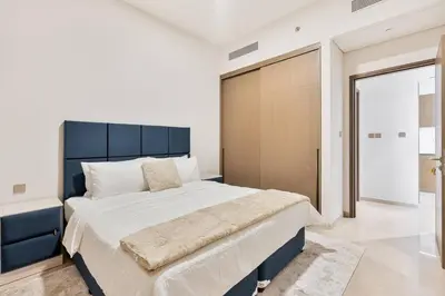 a bedroom with a large bed with a blue headboard at Citihome Luxury Finishing 1BR City View in Dubai