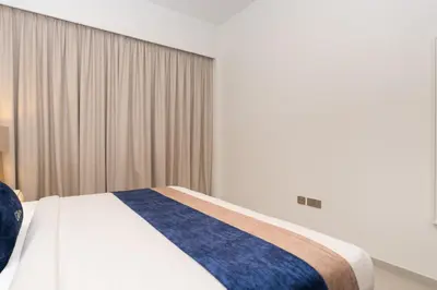 a bedroom with a bed with a blue and white blanket at CitiHome Modern and Cozy Prime Location in Dubai