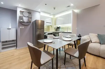a kitchen and a living room with a table and chairs at Upgraded Bay Central 1 Bed - Marina and Pool View in Dubai