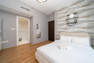 a bedroom with a white bed and a stone wall at Upgraded Bay Central 1 Bed - Marina and Pool View in Dubai