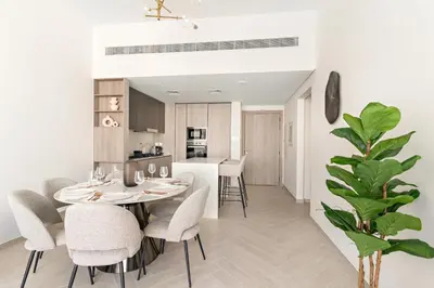 a kitchen and dining room with a table and chairs at VayK - Stylish 2BR with Premium Amenities in JVC in Dubai