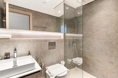 a bathroom with a sink and a glass shower at VayK - Stylish 2BR with Premium Amenities in JVC in Dubai