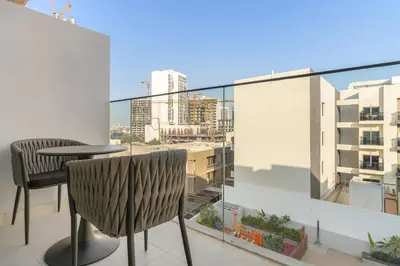 a balcony with a table and chairs and a view of a city at VayK - Stylish 2BR with Premium Amenities in JVC in Dubai
