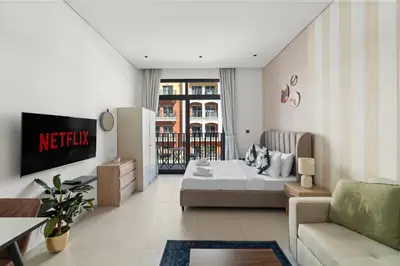 a hotel room with a bed and a living room at VayK - Contemporary and Cozy Studio in JVC in Dubai