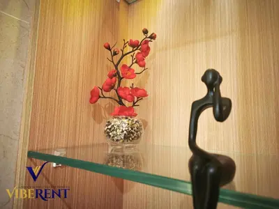 a vase with red flowers sitting on a glass shelf at Luxury 1BHK Pool Paddle Sauna in Dubai