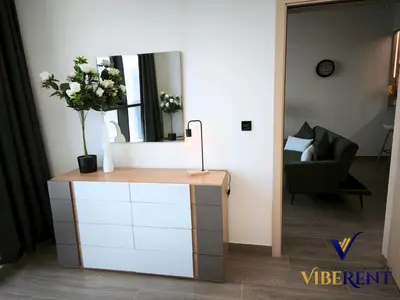 a mirror on top of a dresser in a living room at Luxury 1BHK Pool Paddle Sauna in Dubai