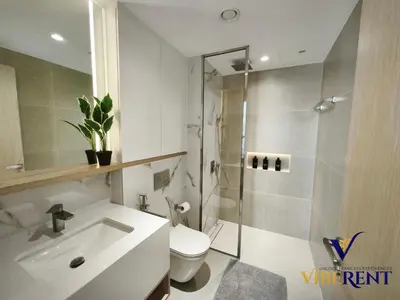 a bathroom with a shower and a toilet and a sink at Luxury 1BHK Pool Paddle Sauna in Dubai