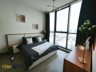 a bedroom with a bed and a large window at Luxury 1BHK Pool Paddle Sauna in Dubai