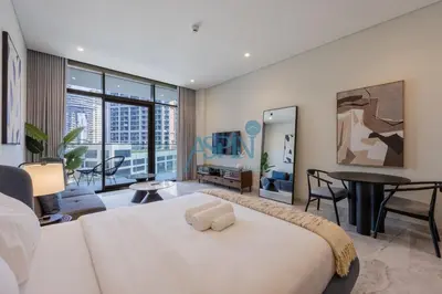 a bedroom with a white bed and a living room at Iconic Burj Khalifa View- Aspin Studio in Dubai