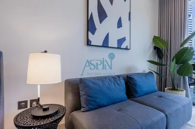 a living room with a blue couch and a table at Iconic Burj Khalifa View- Aspin Studio in Dubai
