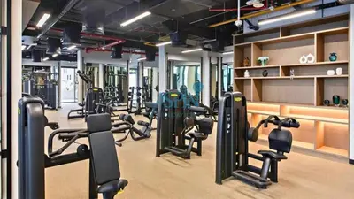 a gym with rows of treadmills and machines at Iconic Burj Khalifa View- Aspin Studio in Dubai