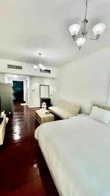 a bedroom with two beds and a living room at Zing Holiday Home in Dubai