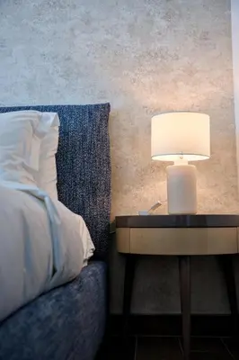 a table with a lamp on it next to a bed at Sobha Hartland Greens 2BR near Dubai Mall in Dubai