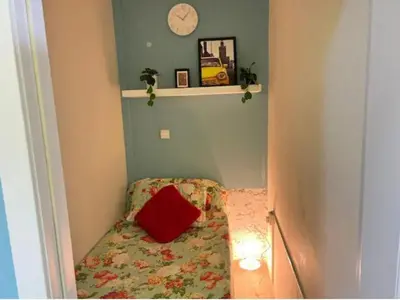 a small room with a bed with a red pillow at Comfort Corner In Al Barsha 1 near Mall of Emirates in Dubai