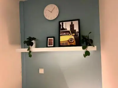 a shelf with a clock and a picture of a car at Comfort Corner In Al Barsha 1 near Mall of Emirates in Dubai