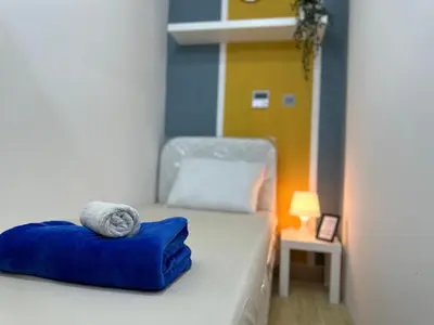 a bedroom with a bed with blue pillows on it at Cozy Barsha Spot In Barsha 1 in Dubai