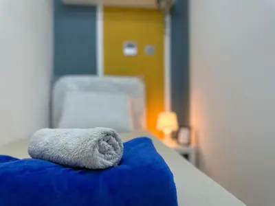 a towel laying on a bed with a blue blanket at Cozy Barsha Spot In Barsha 1 in Dubai