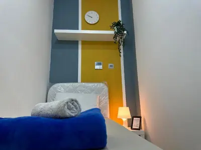 a bedroom with a bed with a clock on the wall at Cozy Barsha Spot In Barsha 1 in Dubai