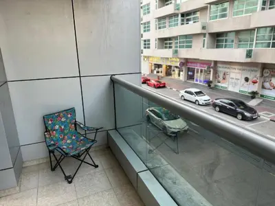 a balcony with a chair and a view of a city at Cozy Barsha Spot In Barsha 1 in Dubai