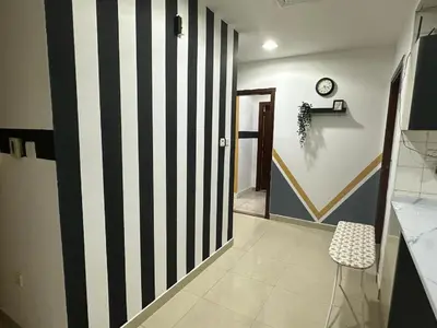 a hallway with a black and white striped wall at Cozy Barsha Spot In Barsha 1 in Dubai