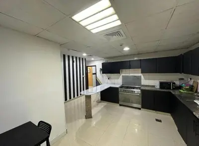 a kitchen with black and white cabinets and a stove at Solo Comfort Corner In Barsha 1 in Dubai