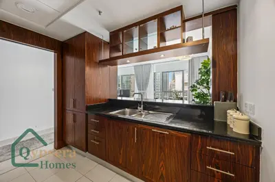 a kitchen with wooden cabinets and a sink and a window at Iconic Burj & Fountain View Retreat! in Dubai