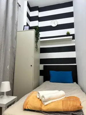 a bedroom with a bed with a striped wall at City Lux Stay In Al Barsha 1Near Mall of Emirates in Dubai