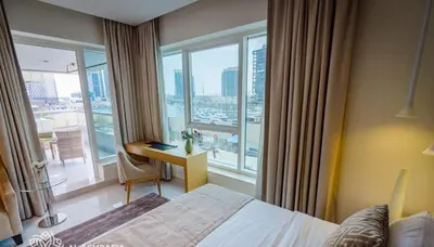a bedroom with a bed and a desk with a window at Dreamstay 2 BR in Business Bay in Dubai