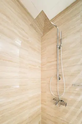 a shower in a bathroom with a wooden wall at Gala Guests - Urban Oasis Apartments Near Burj Khalifa & Downtown Dubai in Dubai