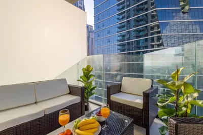 a balcony with a couch and a table with fruit on it at Gala Guests - Urban Oasis Apartments Near Burj Khalifa & Downtown Dubai in Dubai