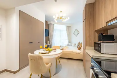 a small kitchen and living room with a table and chairs at Gala Guests - Urban Oasis Apartments Near Burj Khalifa & Downtown Dubai in Dubai