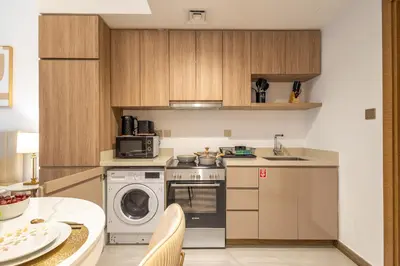 a kitchen with a washing machine and a washer at Gala Guests - Urban Oasis Apartments Near Burj Khalifa & Downtown Dubai in Dubai