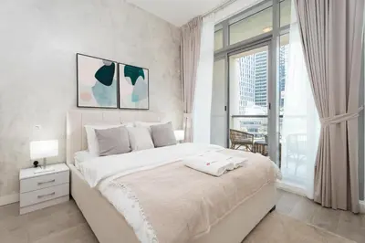 a white bedroom with a large bed and a window at Gala Guests - Iris Blue Luxe Living Collection in Dubai