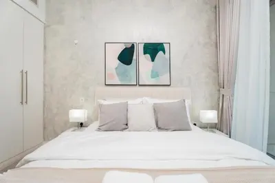 a bedroom with a white bed with three pictures on the wall at Gala Guests - Iris Blue Luxe Living Collection in Dubai
